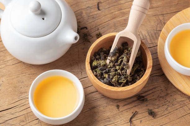 istock Dried tea leaves in bowl with tea set on wood table 1957121614
