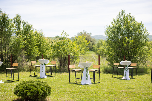 Party set up with tables and chairs outdoors on a meadow.
