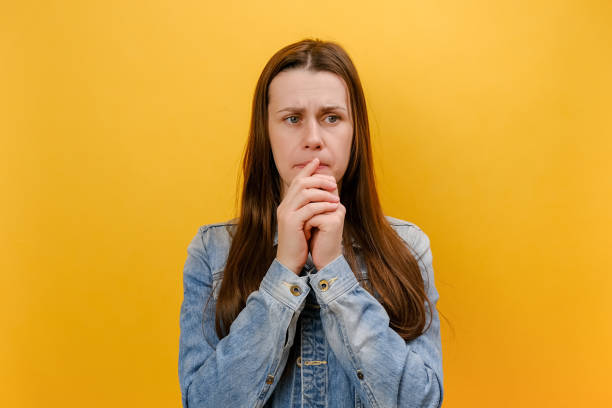portrait of exhausted nervous young woman showing mind explosion gesture, feeling unhappy, lots unnecessary information, wearing denim jacket, posing isolated on yellow color background wall in studio - overstrained imagens e fotografias de stock