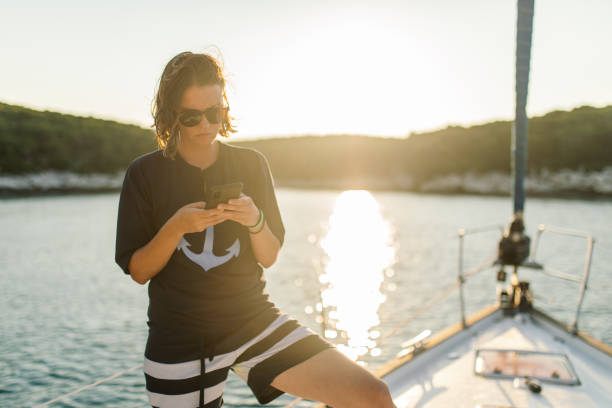 istock Woman using phone on a sailboat 1957163859