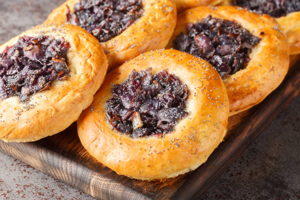 Cebularz Lubelski is a round-shaped Polish Onion poppy flatbread close-up on a wooden board. Horizontal Cebularz Lubelski is a round-shaped Polish Onion poppy flatbread close-up on a wooden board on the table. Horizontal kosher starter recipes stock pictures, royalty-free photos & images