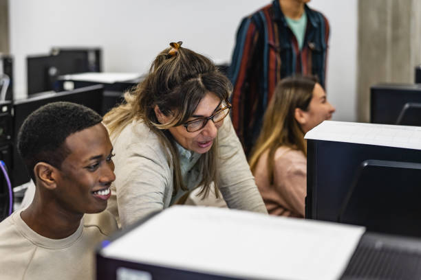 istock Young Afro American student with teacher during university lesson in classroom - Education and technology concept 1957170021