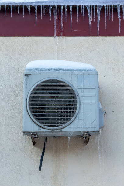 istock The conditioner covered with icicles on a yellow wall. 1957173346