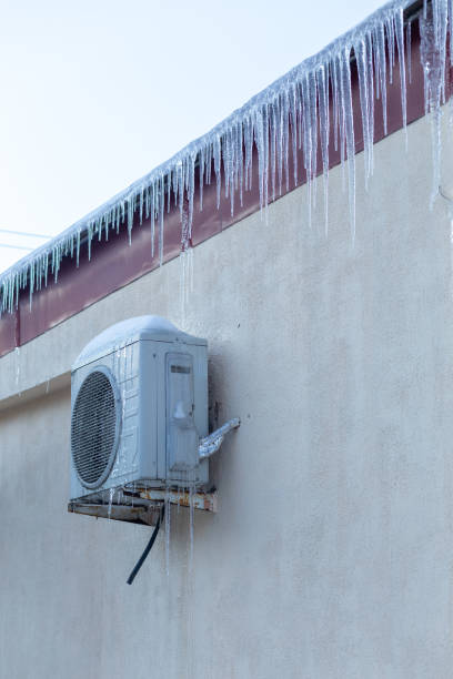 istock The conditioner covered with icicles on a yellow wall. 1957178889