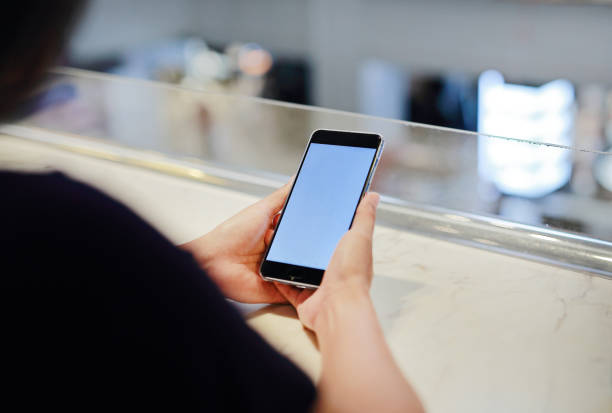 istock Female hands holding smart phone with empty black screen. 1957197189