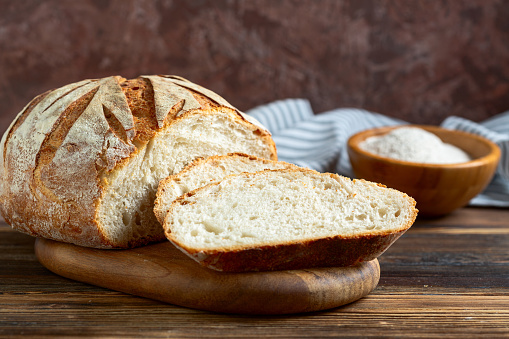 Artisanal sourdough wheat bread on a wooden table, selective focus.