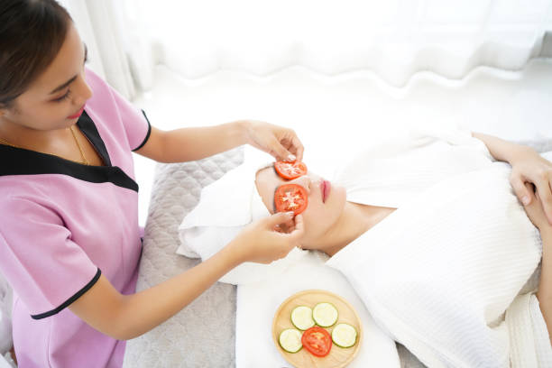 masseuse masking face with tomato and spa face woman treatment and massage aroma therapy relax enjoying and healthy and beauty. - alternative therapy stone zen like nature - fotografias e filmes do acervo