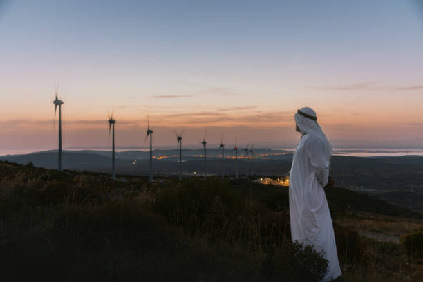 istock Middle Eastern Businessman in wind turbine farm at sunset 1957203203