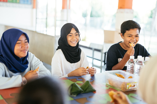 School children in canteen eating snack, in school in South East Asia