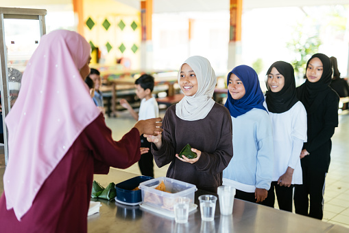 School children in canteen eating snack, in school in South East Asia