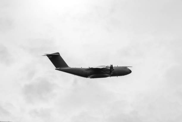 Transport plane in flight against a gray sky.