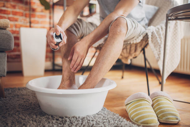 istock Man relaxing at home having a foot bath 1957205395