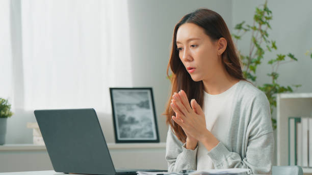istock Professional young Asian female freelancer or office employee using computer laptop, meeting with co-worker partner team on video call conference and working remotely from home, Confident female manager working at home office 1957207562