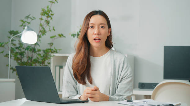 istock Happy young Asian female worker or cheerful employee using computer laptop, working with colleage partner team on video call conference on internet and working remotely from home, Confident office employee working at home office 1957207581