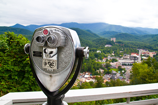 Capture the beauty of Gatlinburg, Tennessee with this scenic vista. Explore the lush greenery and rolling hills from the convenience of a coin-operated binocular viewer. Perfect for travel and nature enthusiasts looking to discover hidden wonders.