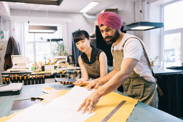istock Leathercraft artisans working together on a new design in their studio space 1957214056
