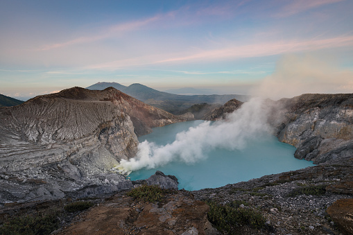 Famous Ijen volcano crater and acidic lake panoramic view during colorful sunrise in East Java