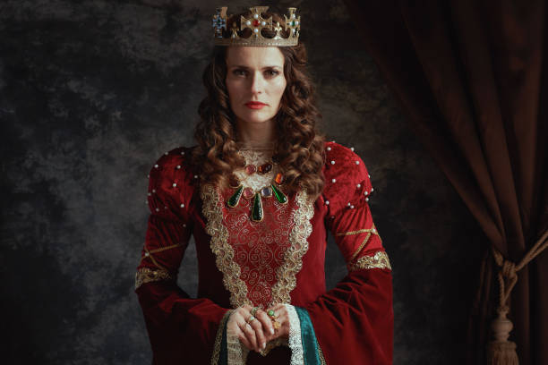 istock medieval queen in red dress with crown 1957252019