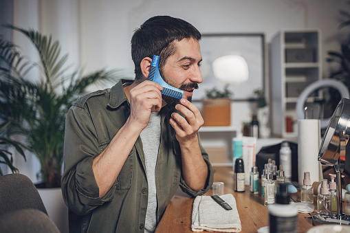 Man grooming his beard at home