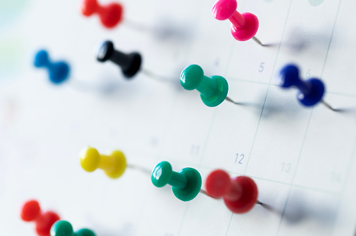 Calendar with colored push pins.