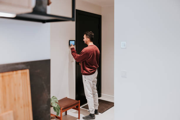 man using smart doorlock in his modern home - security camera installing security system security foto e immagini stock