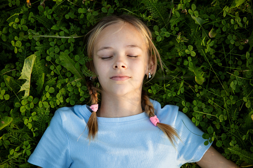 Portrait of a teenage girl lying on the grass.