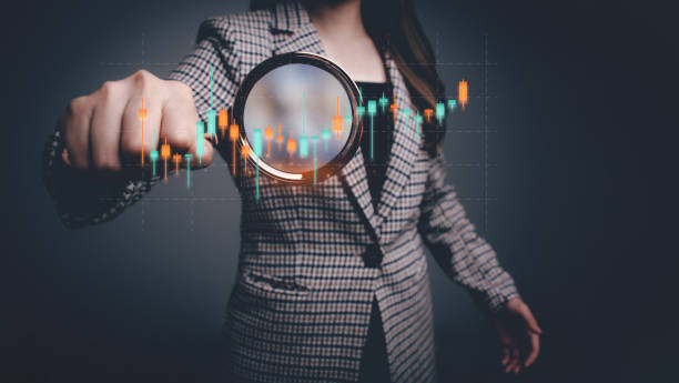 istock Businesswoman using magnifying glass focus to virtual financial graph chart icon about business finance and investment. Business growth up, planning, strategy, business start up concept. 1957278553