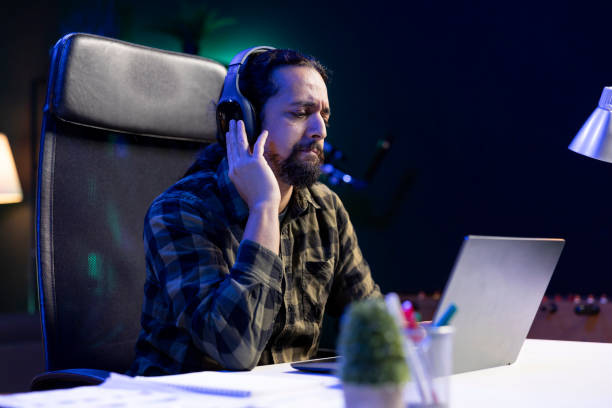 istock Focused guy using headphones and laptop 1957299424