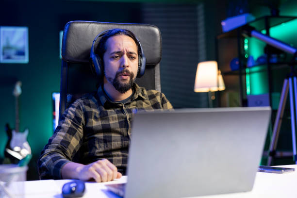istock Man with headset watching film on laptop 1957303260