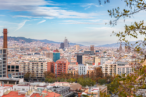 Aerial view on Barcelona residential area and skyline,  mountain ridges in distance under the blue sky