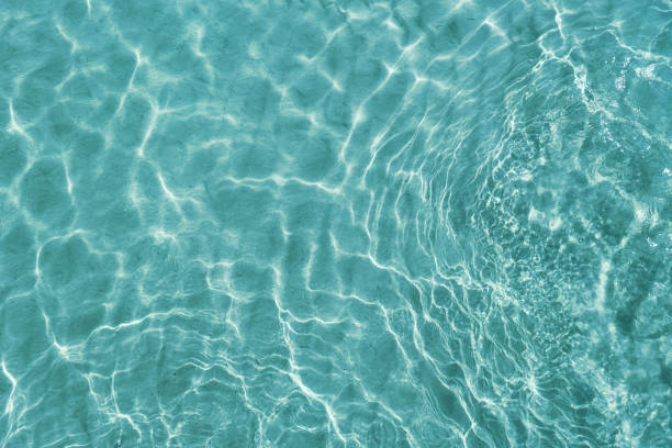 istock Blue water surface viewed from above in outdoor sea, sun reflection, dimply. Surface Abstract Background. Clear water in sea with ripple in clean aqua liquid. Summer wallpaper blue background and reflection of sunlight on water surface. 1957327017