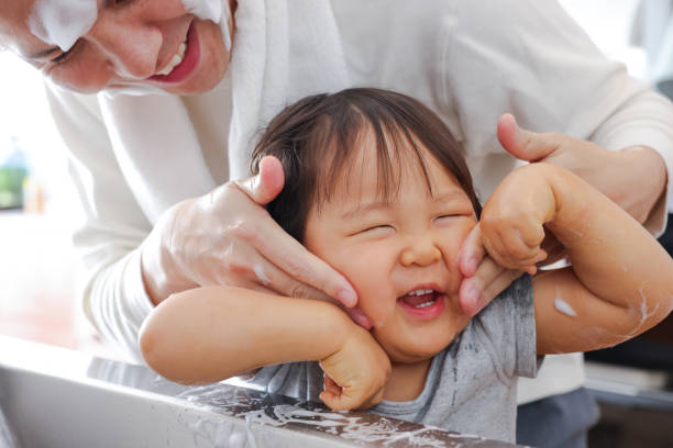 Japanese families face washing during their daily lives.Parent and children showing expressions of happiness and contentment as they clean their skin.