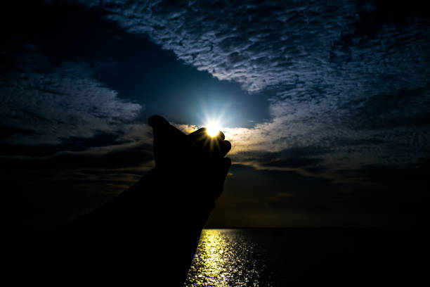 istock Sunlight on fingers hand in the evening. 1957365847