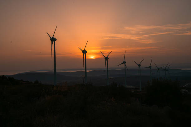 Aerial view large group of eco system wind turbines power generation station on green field in rural landscape in countryside in sunny summer sunshine time. xxxl size