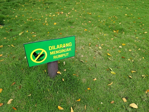 Keep off the grass (dilarang menginjak rumput) sign in a meadow