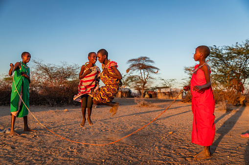African children from Samburu tribe children having fun with jumping rope in the village, Kenya, East Africa. Samburu tribe is north-central Kenya, and they are related to  the Maasai.