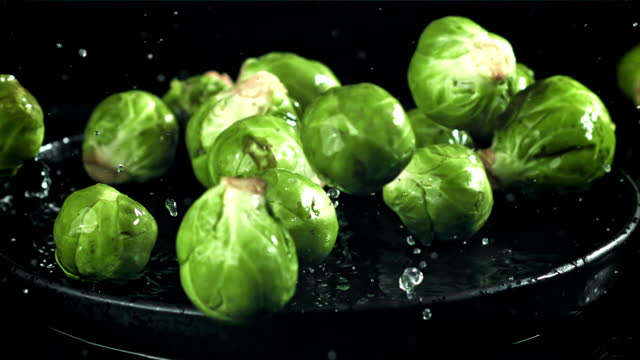 Brussel sprouts fall on a wet plate. Filmed on a high-speed camera at 1000 fps.