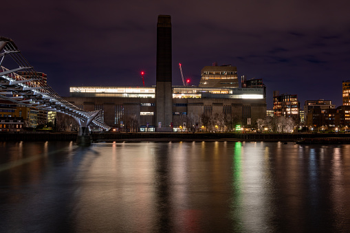 London. UK-01.20.2024. A long exposure night time view of the Tate Modern Gallery from the north bank of the river Thames