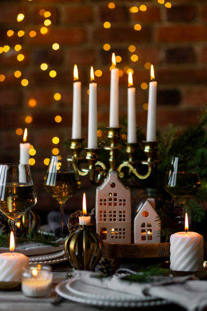 istock Rustic elegant table decor for christmas family dinner. Center piece with white candle, pine cone, fir tree branches. Zero waste eco-friendly home decoration. Cozy atmosphere, wooden background. 1957431231