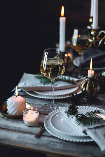 istock Rustic elegant table decor for christmas family dinner. Center piece with white candle, pine cone, fir tree branches. Zero waste eco-friendly home decoration. Cozy atmosphere, wooden background. 1957432337