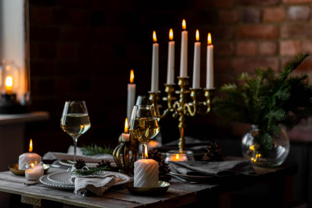 istock Rustic elegant table decor for christmas family dinner. Center piece with white candle, pine cone, fir tree branches. Zero waste eco-friendly home decoration. Cozy atmosphere, wooden background. 1957432368
