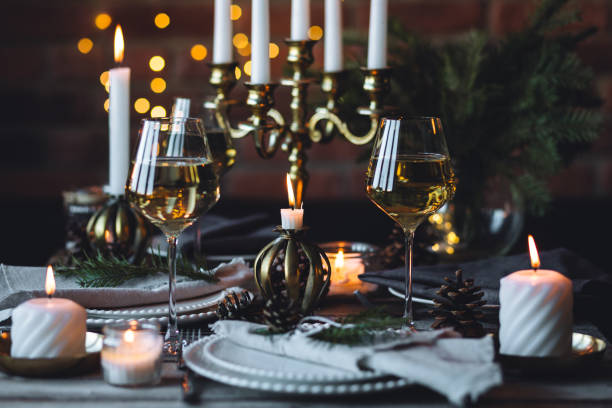 istock Rustic elegant table decor for christmas family dinner. Center piece with white candle, pine cone, fir tree branches. Zero waste eco-friendly home decoration. Cozy atmosphere, wooden background. 1957432377