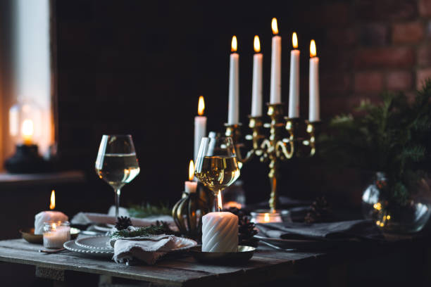 istock Rustic elegant table decor for christmas family dinner. Center piece with white candle, pine cone, fir tree branches. Zero waste eco-friendly home decoration. Cozy atmosphere, wooden background. 1957432378