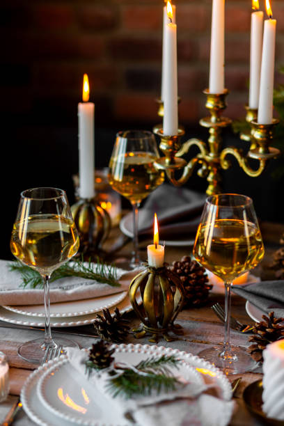 istock Rustic elegant table decor for christmas family dinner. Center piece with white candle, pine cone, fir tree branches. Zero waste eco-friendly home decoration. Cozy atmosphere, wooden background. 1957433496