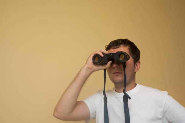 istock A young white man is viewing in binoculars far away, half-turned 1957434035
