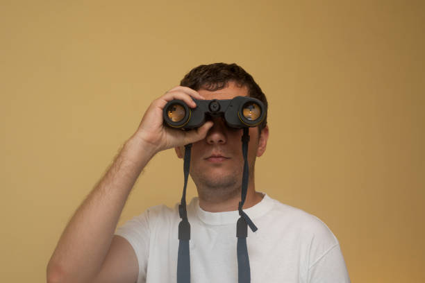 istock A young white man is viewing in binoculars far away, full face 1957434040