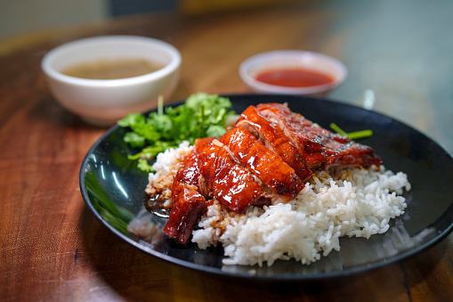 Grilled Beef With Dipping Sauce In White Dish On Wooden Background. Grilled Beef with cooked rice and spicy sauce.