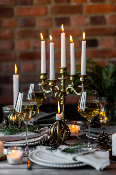 istock Rustic elegant table decor for christmas family dinner. Center piece with white candle, pine cone, fir tree branches. Zero waste eco-friendly home decoration. Cozy atmosphere, wooden background. 1957437904
