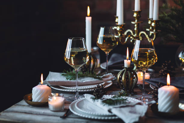 istock Rustic elegant table decor for christmas family dinner. Center piece with white candle, pine cone, fir tree branches. Zero waste eco-friendly home decoration. Cozy atmosphere, wooden background. 1957438460