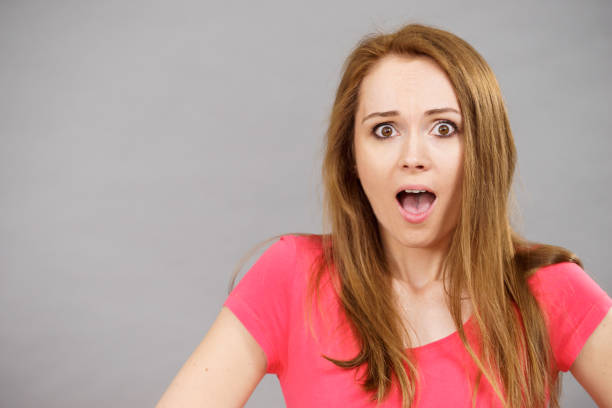 A girl with glasses and comically large googly eyes gasps in surprise - mouth open and hands against the side of her face. White background.